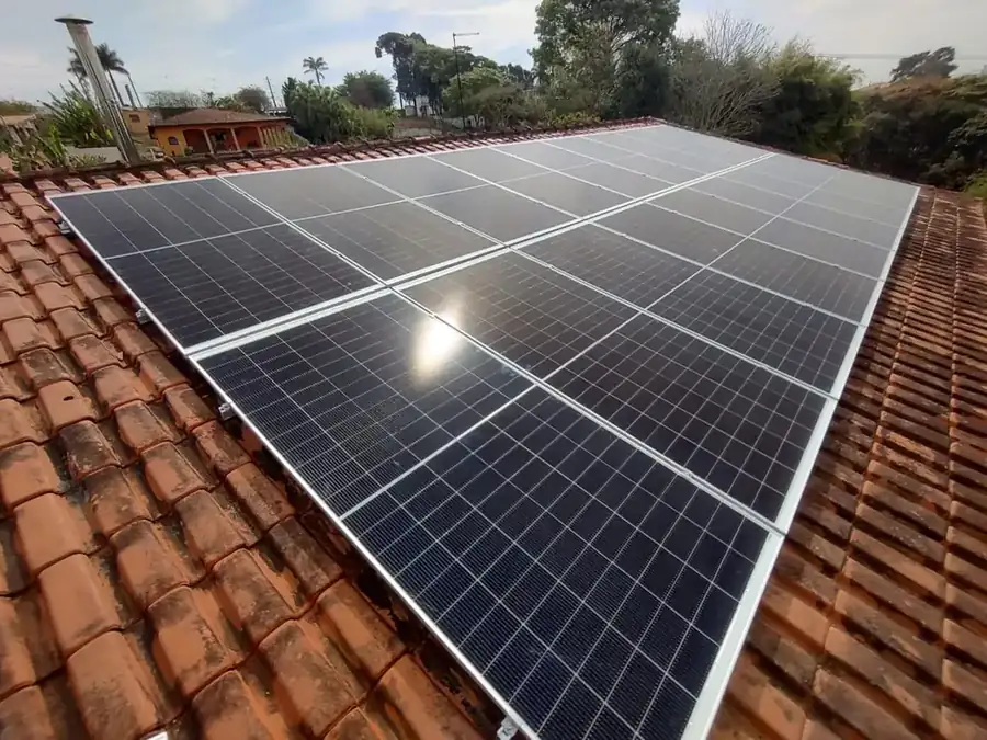 Detalhe de painéis solares instalados em telhado de telhas cerâmicas